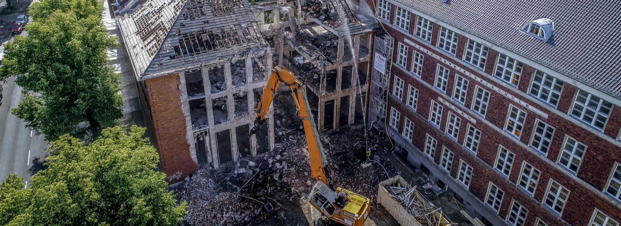 Abbruch eines Backstein-Schulgebäudes in Berlin-Pankow mit Longfront-Bagger der Lula Bau GmbH
